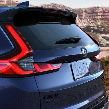 2027 Honda CR-V Sport Touring Hybrid in Canyon River Blue Metallic back parked in a scenic desert canyon (Compact Crossover SUV).
